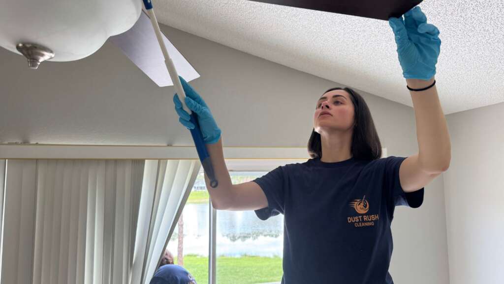 Dust Rush Cleaning professional cleaning a ceiling fan in Oviedo FL